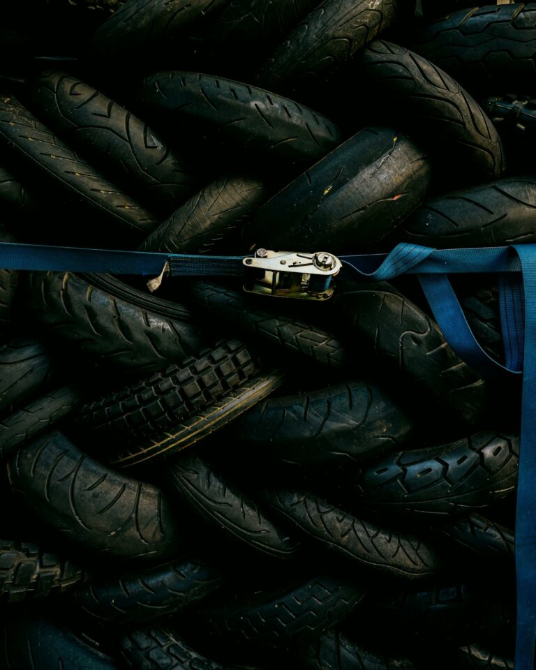A pile of used tires strapped with a blue belt. Industrial and recycling theme.