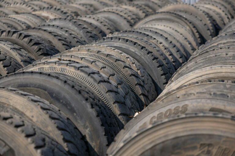 Rows of used tires arranged outdoors, showcasing texture and pattern.